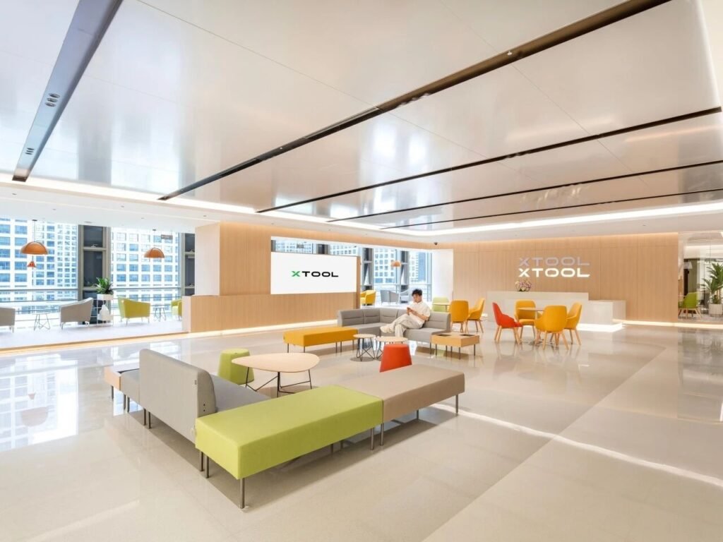 科技公司前台接待大廳：灰白原木基調配黃橙藍綠點綴，開放式接待空間